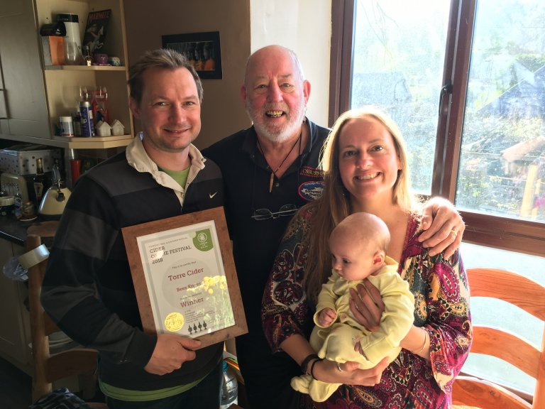 Presentation by Chairman Mick of the certificate for Cider of the Festival for Bees Knees to Neil, Gemma and baby Maggie at Torre Cider Farm in Washford.