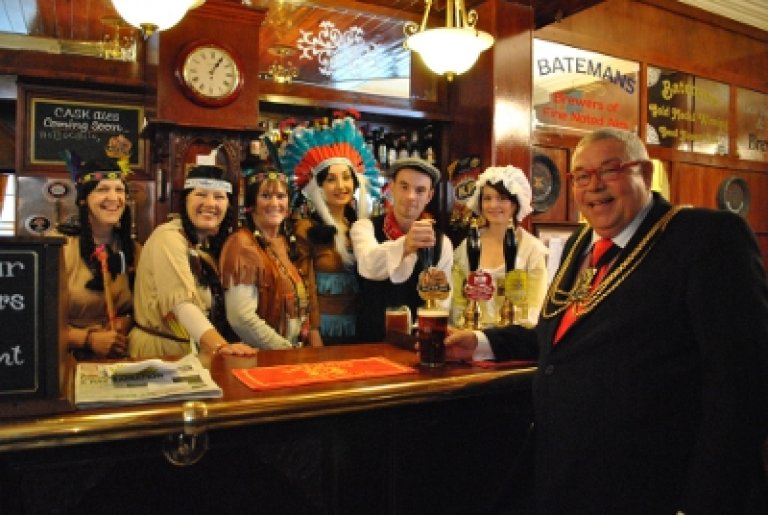 Ready at the Indian Queen Ale pump in the Indian Queen and Three Kings pub, from left: Lucy Taylor, Glyn Ruskin, Paula Naylor (all from Boston Playgoers), Beth Warsop (Pocahontas), landlord and landlady Aaron Queen and Charlotte Syer and Mayor Cllr Paul Kenny.