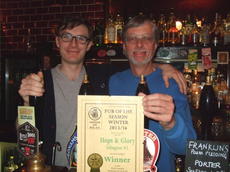 Durham Atkinson (left) of Hops & Glory receives the CAMRA North London 2013/2014 Winter Pub of the Season Award from CAMRA's John Cryne. 