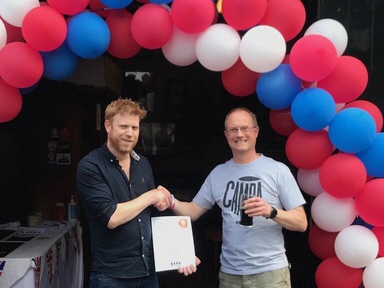 North Surrey CAMRA Secretary Anthony, presents Olde Swan Chertsey landlord Phil with his 2022 Pub of the Year Certificate.