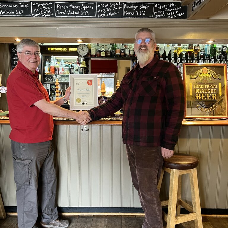 CAMRA Chair Richard James presents the Pub of the Year certificate to Five Bells landlord Simon Cole.