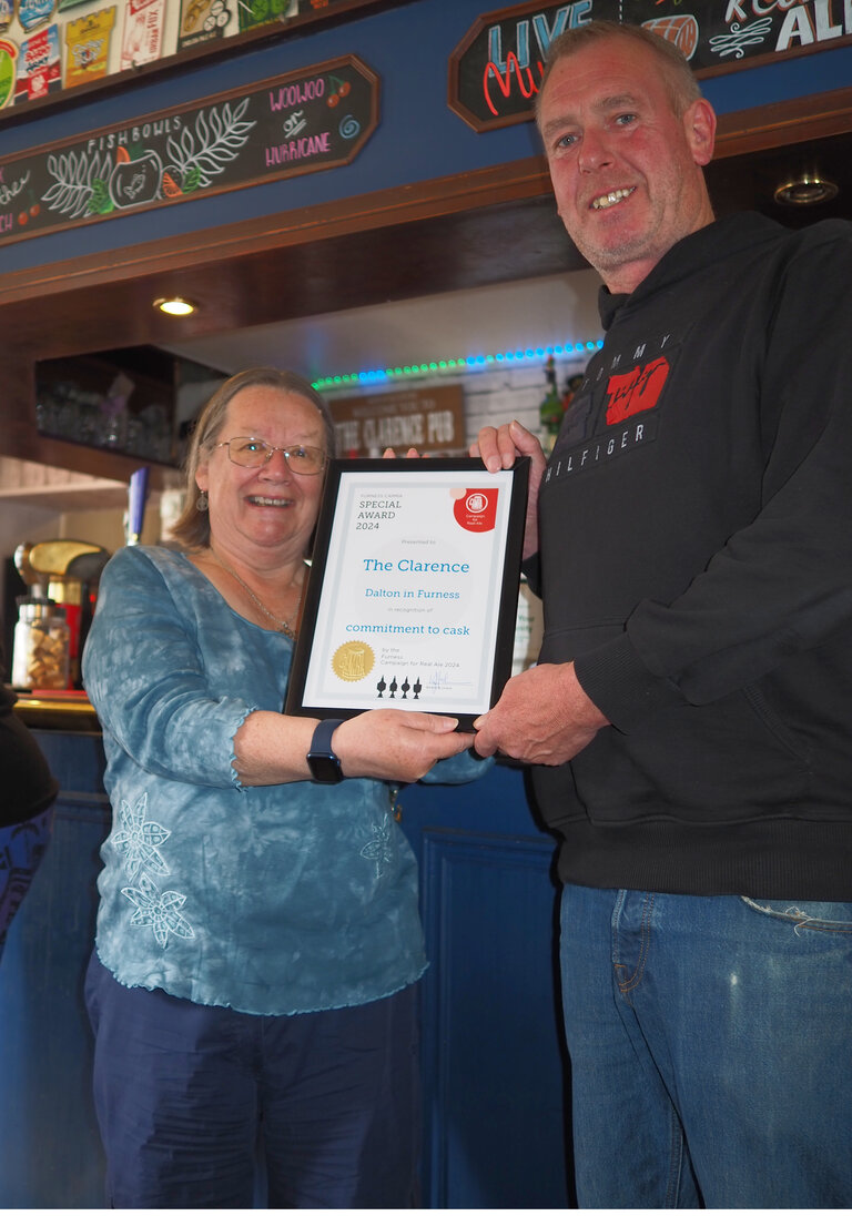 Kieran McDaid, Landlord of The Clarence receives the certificate for 'commitment to cask' from Ann Summers-Glass (Furness CAMRA)