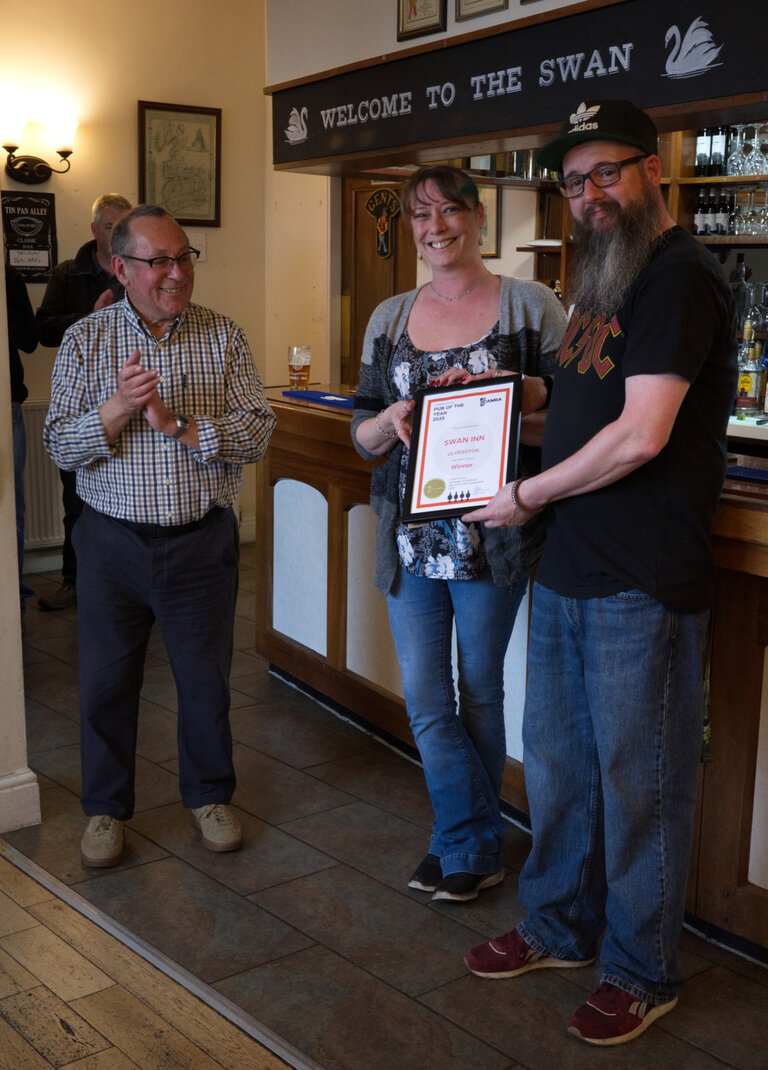 At The Swan in Ulverston, Sarah and Lewis receive the CAMRA Certificate for Furness Pub of the Year 2025 from Dave WIlson. This is the second year running that The Swan has picked up the award. Well done!