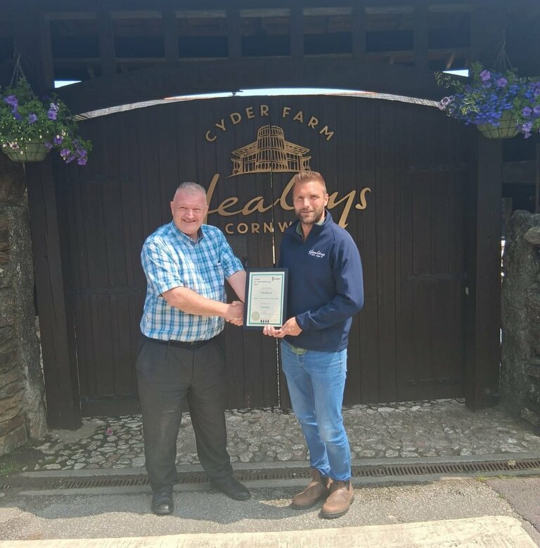 Eddie Knorn presents cider of the fiestival certificate 2025 to 
Liam, operations officer at Healeys Cider