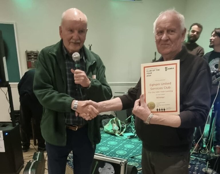 Spike presenting Egham United Services Club Vice President Alan Purvis with  their 2026 Club of the Year Award