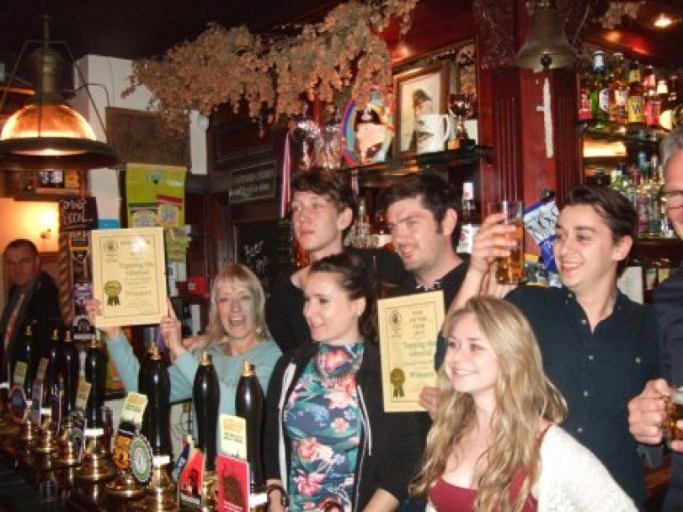 Christine Cryne (left with certificate) helps the Tapping team celebrate their success in the CAMRA North London 2015 Pub of the Year competition. 